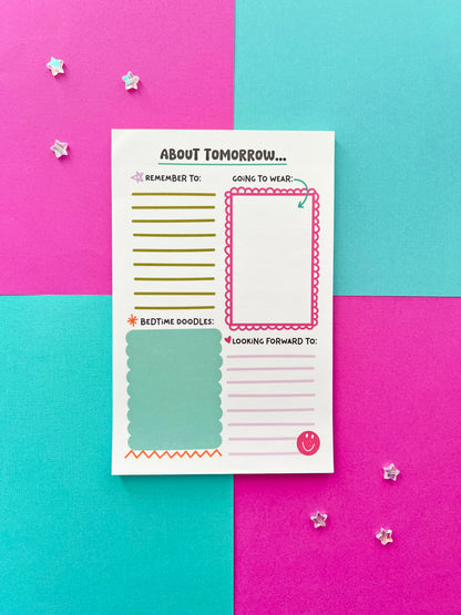 Kids bedtime and morning routine notepad on colorful background. ‘About Tomorrow’ daily planning pad for children with sections for reminders, outfit planning, doodles, and happy thoughts.