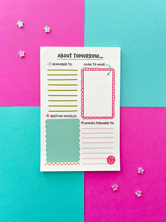 Kids bedtime and morning routine notepad on colorful background. ‘About Tomorrow’ daily planning pad for children with sections for reminders, outfit planning, doodles, and happy thoughts.