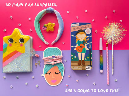 Flat lay of unique toys and stationery accessories inside a creative girls gift box package with a surprise banner.