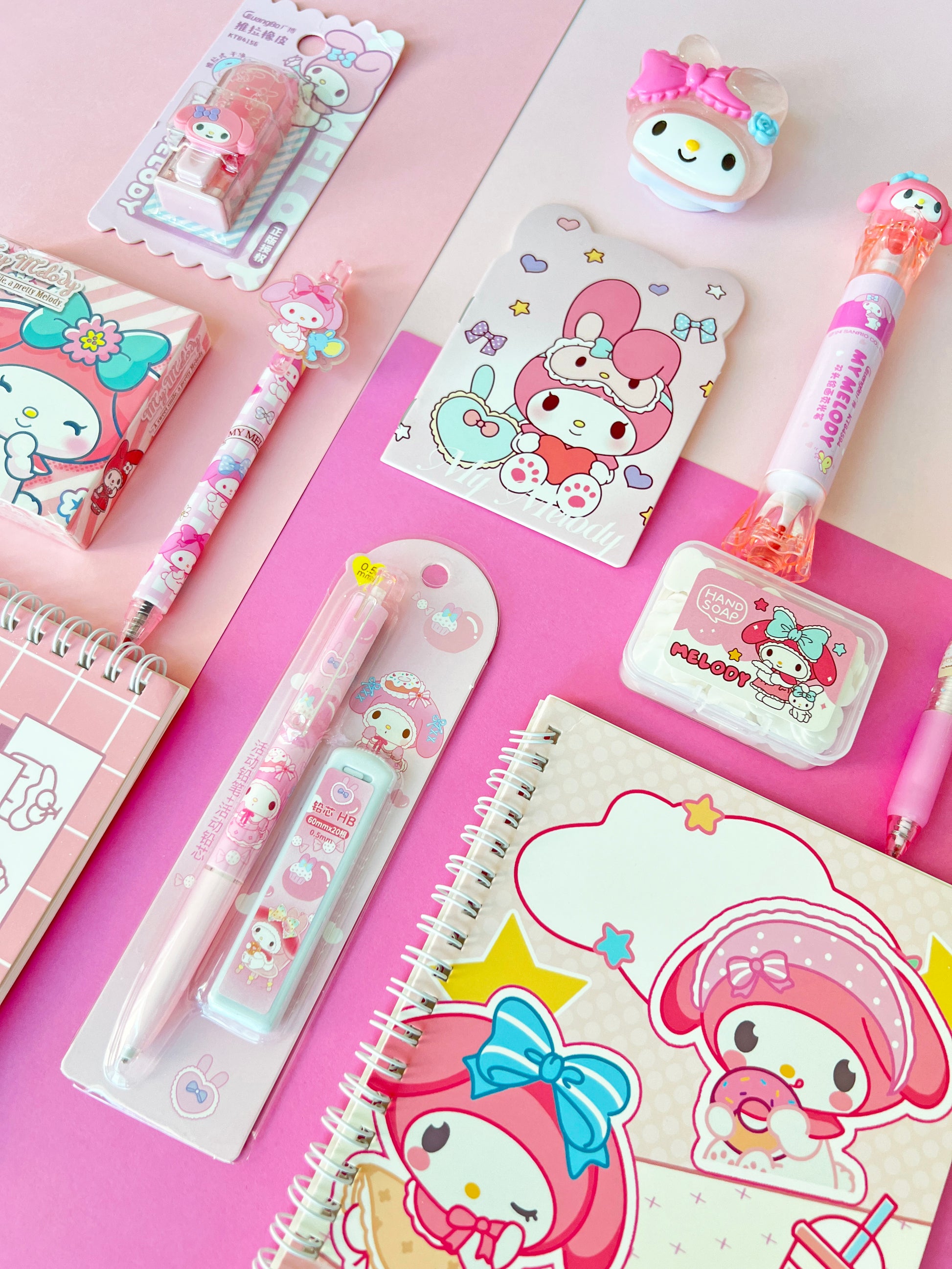 Cute pink cartoon bunny character stationery items with pens, a mini notepad, and decorative stickers for desk organization.