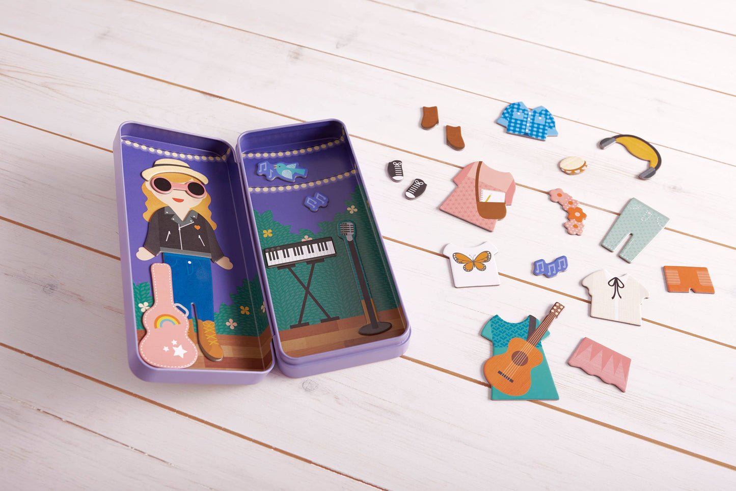 Open storage tin showcasing all 25 magnetic pieces and accessories included in the kids dress-up play set.