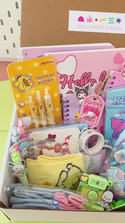 Video showing a close-up unboxing and packing process of a colorful pastel cartoon stationery mystery box gift.