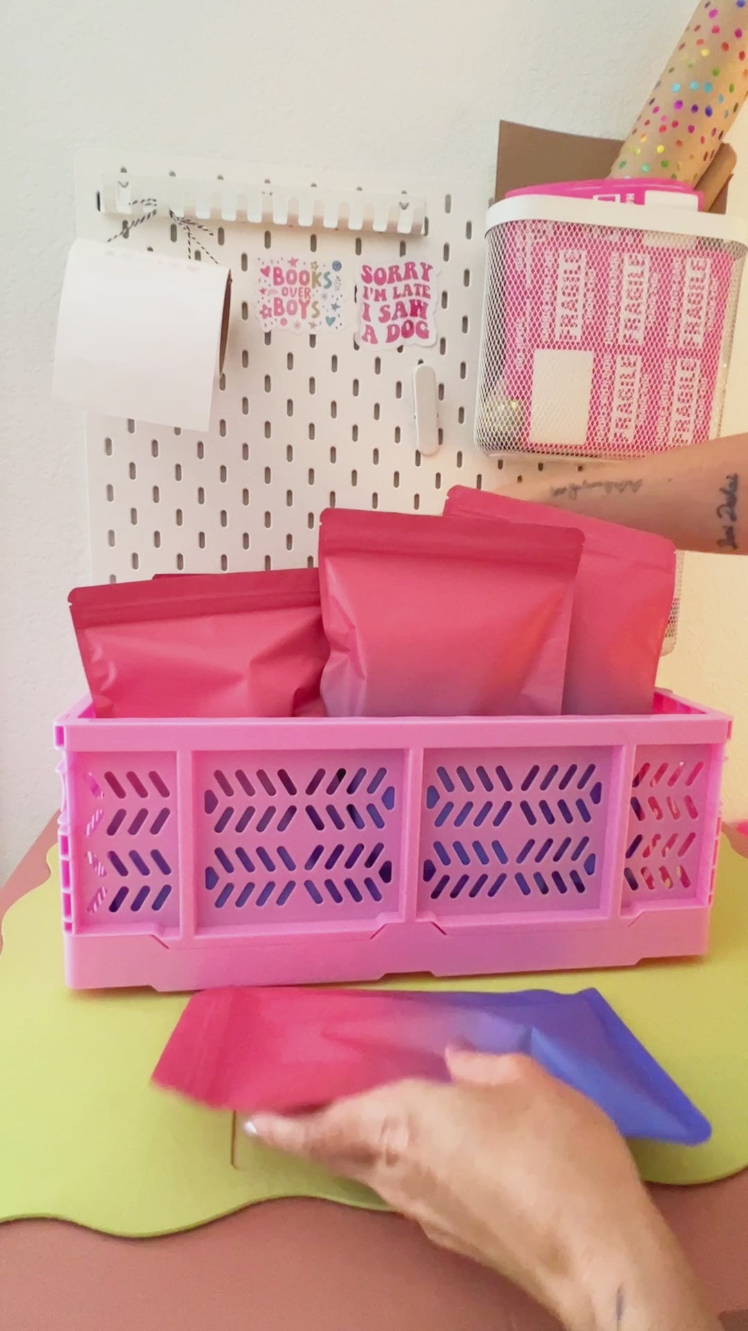 Video revealing colorful cartoon mystery gift bags being packed into a bright pink mini plastic storage crate.